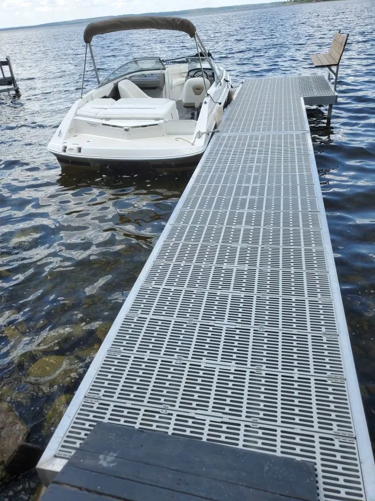Aluminum dock with ThruFlow decking and moored boat on calm lake