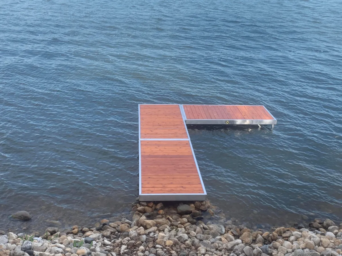 L-shaped aluminum dock with cedar decking off rocky shoreline