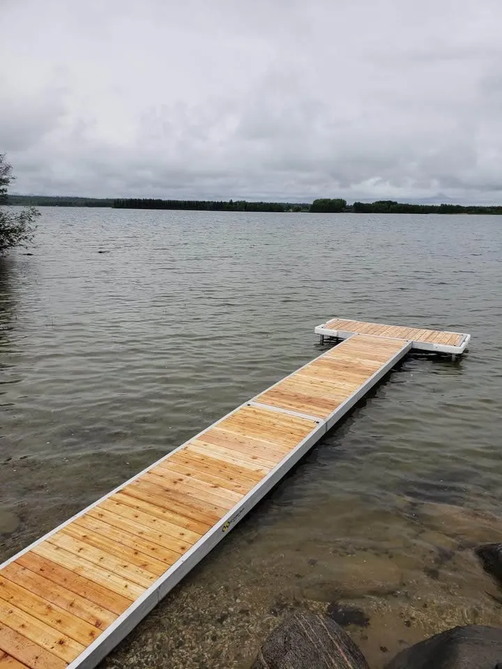 Cedar-decked aluminum dock extending into a calm northern lake