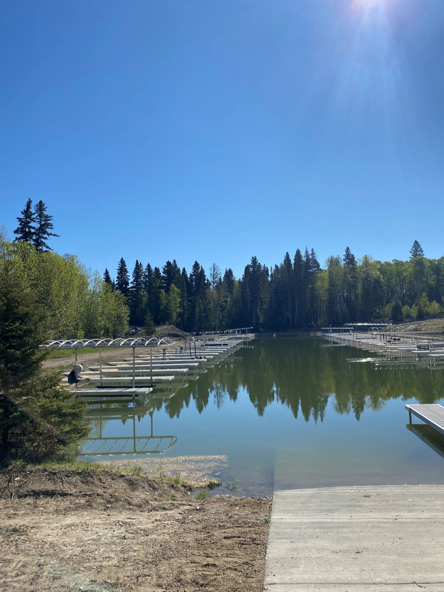 Aluminum dock system on a calm Saskatchewan lake surrounded by boreal forest